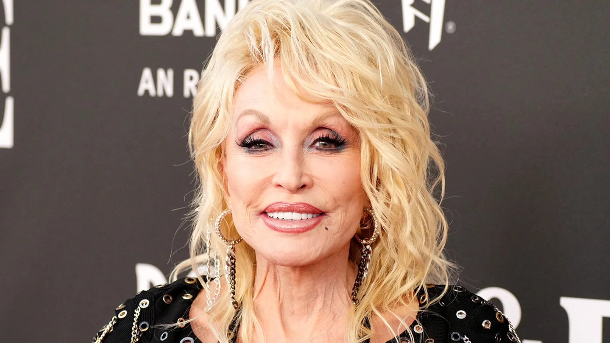 Country legend Dolly Parton smiling on stage at a music event