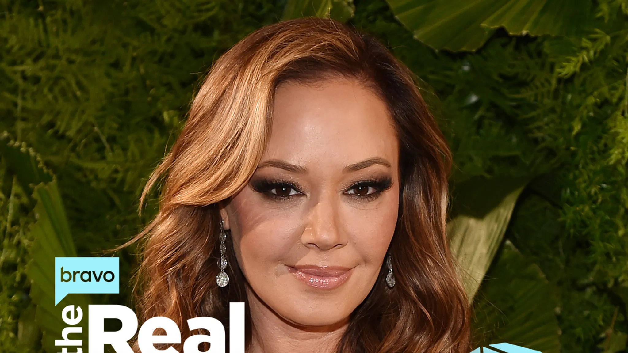 Leah Remini posing on a red carpet in a black jacket