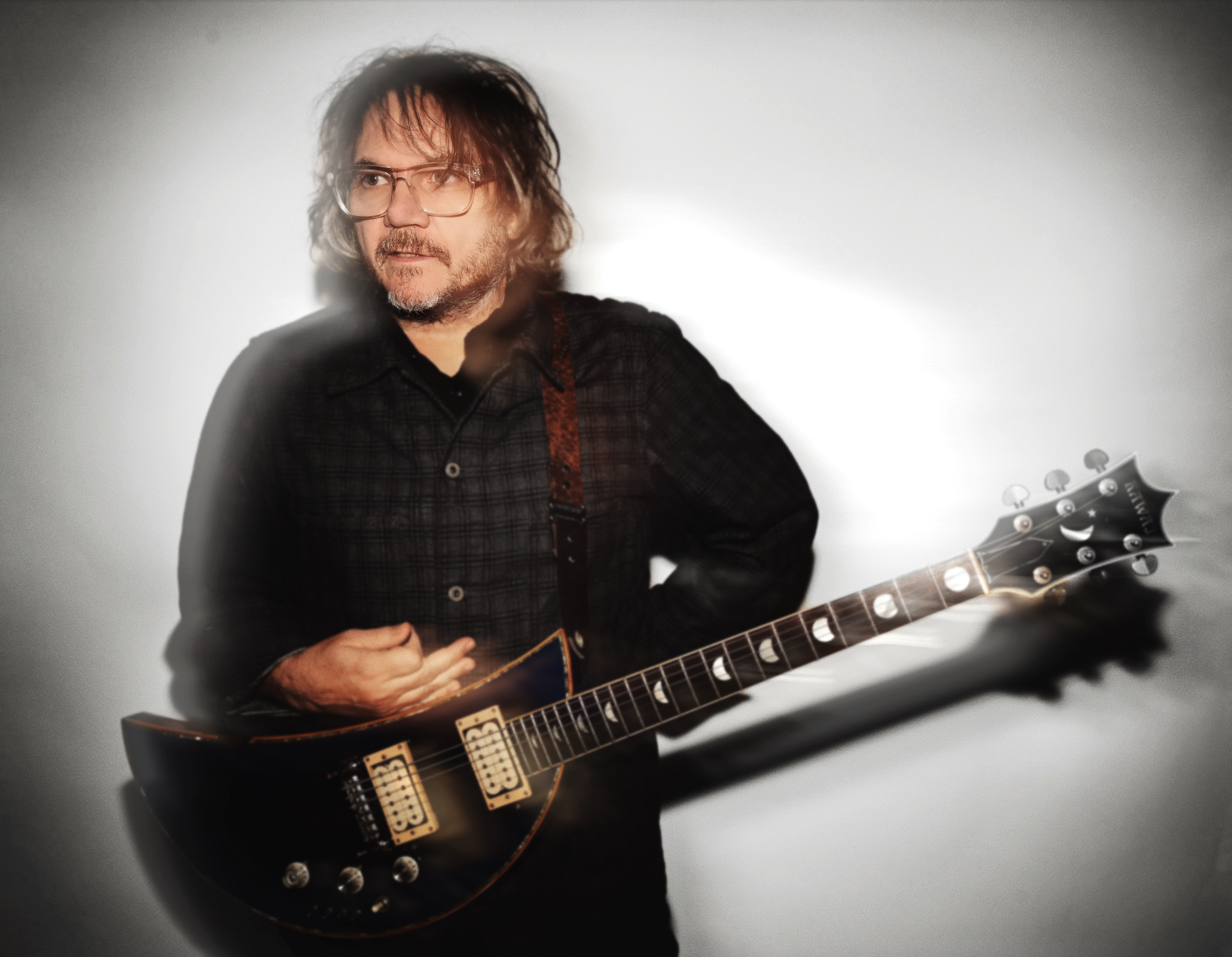 Jeff Tweedy performing on stage with Wilco