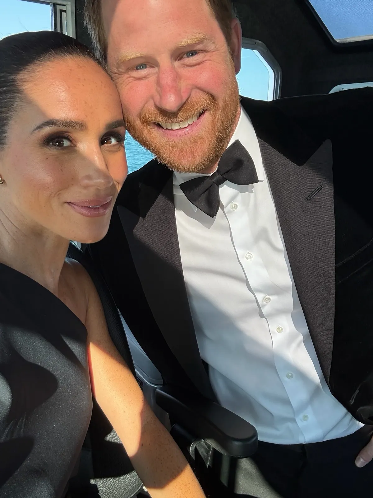 Meghan Markle and Prince Harry smiling in a selfie.