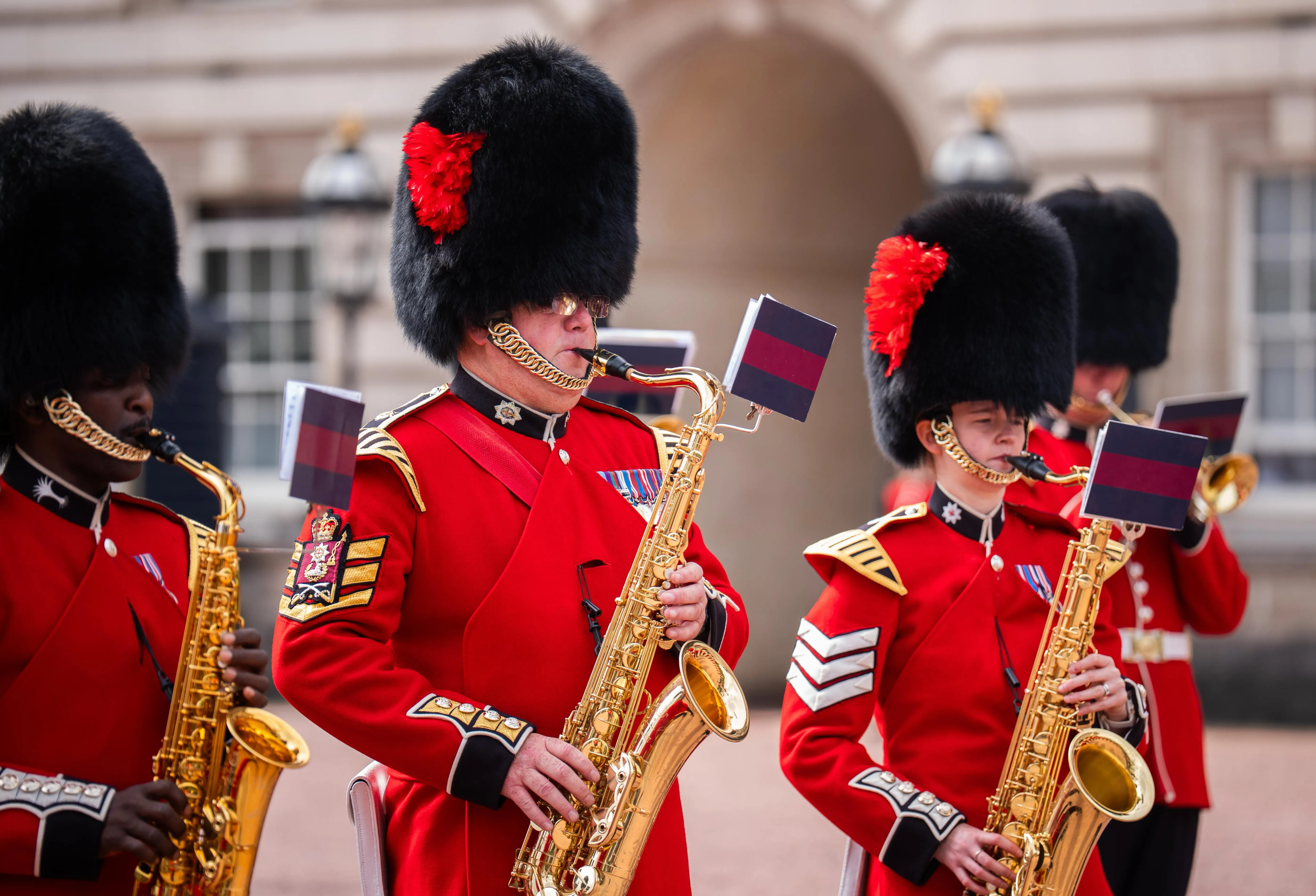 Members of the Coldstream Guards and Welsh Guards playing saxophones during the Changing of the Guard at Buckingham Palace.