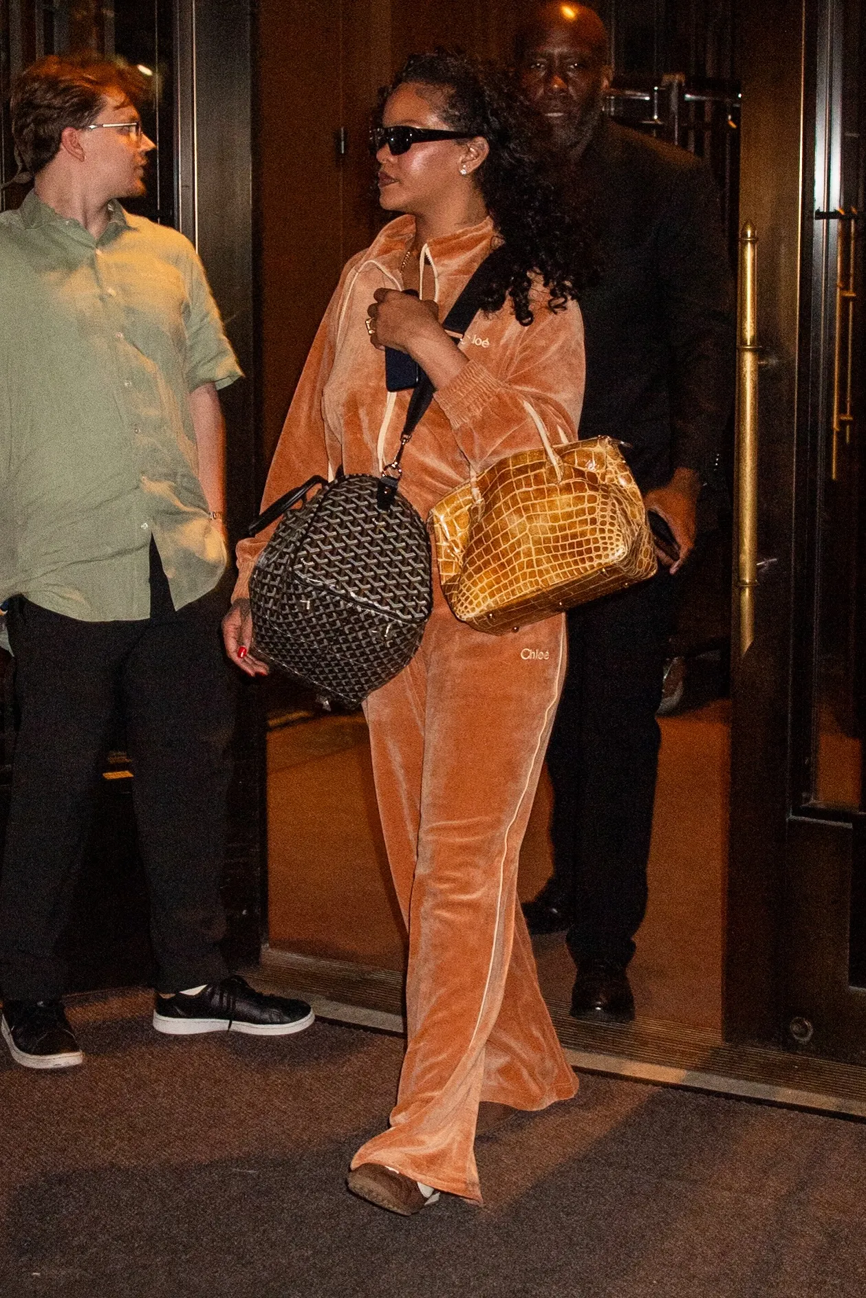 Rihanna in a camel-colored velour tracksuit leaving with her security team.