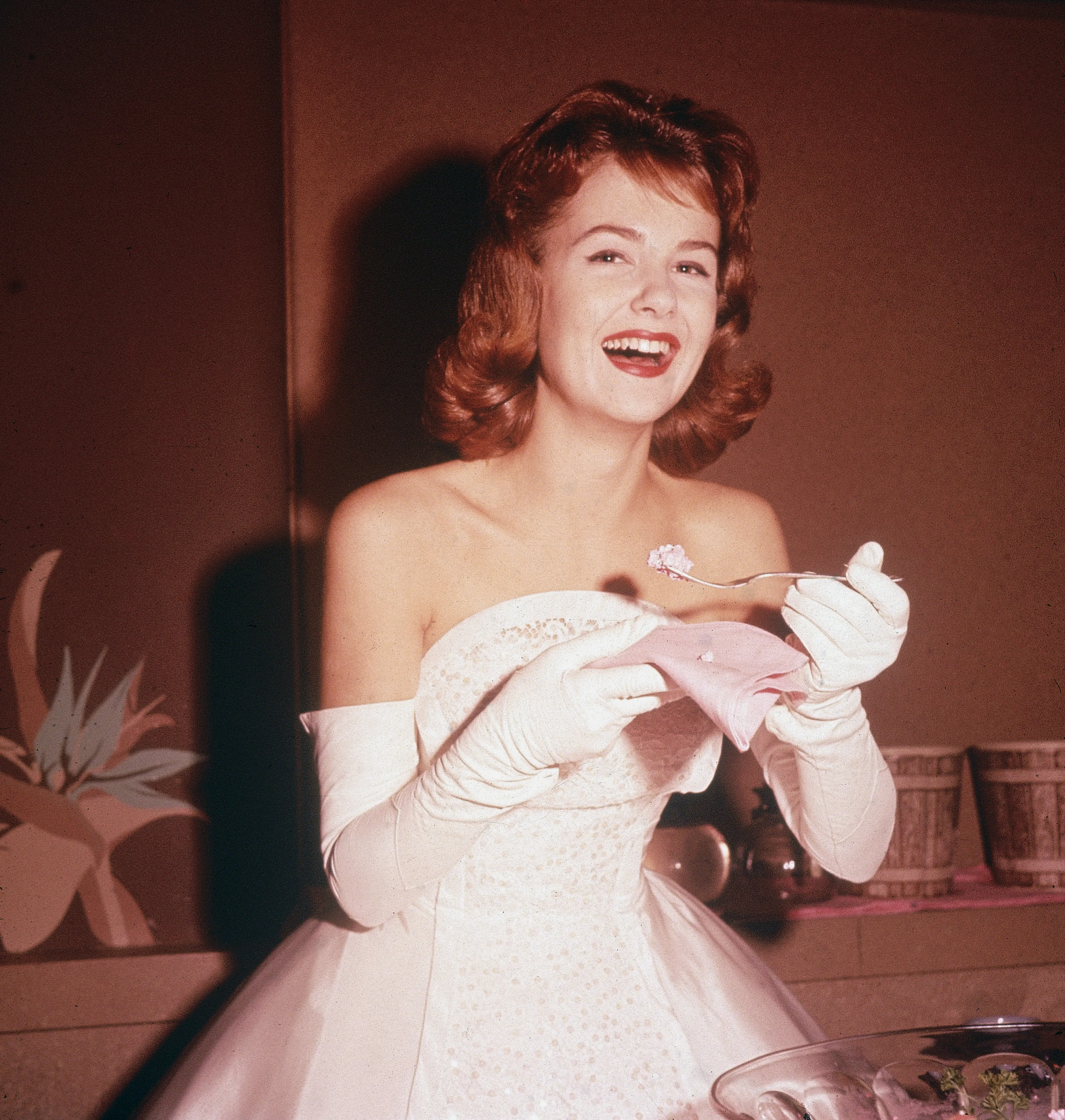 American actor Shelley Fabares laughs while eating cake.