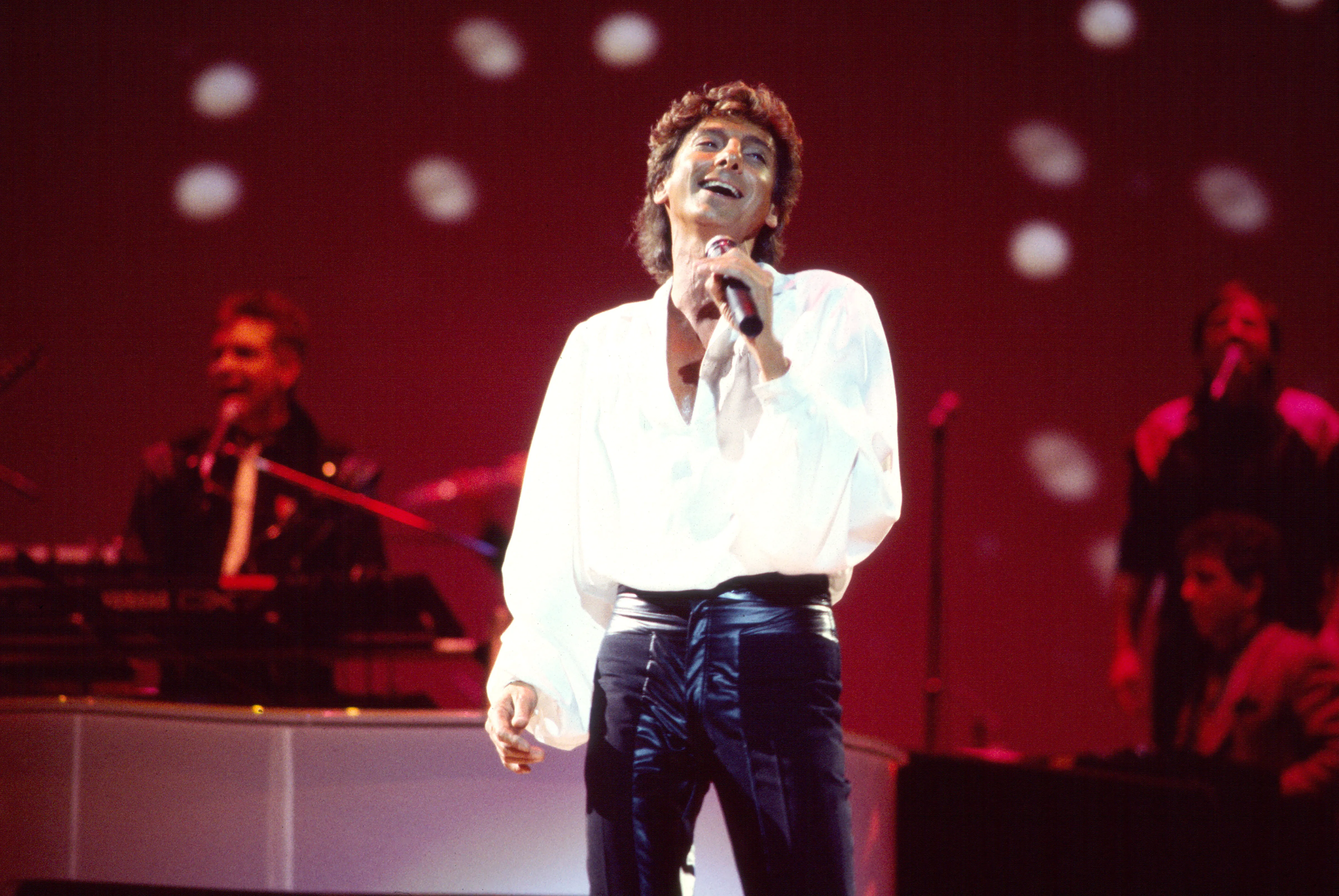 Barry Manilow performing onstage with his band.