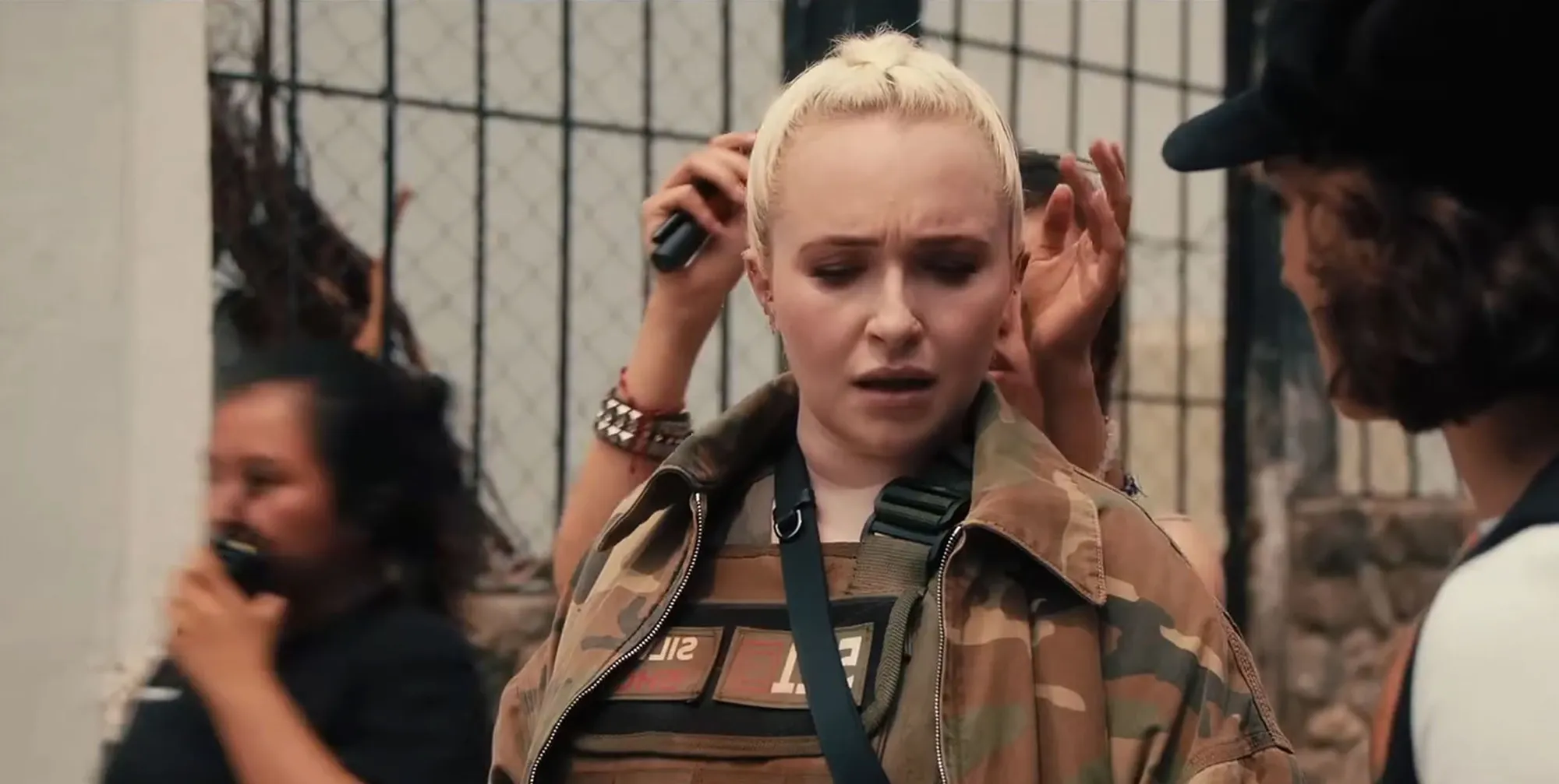 Hayden Panettiere in military-style clothing, with others around her.