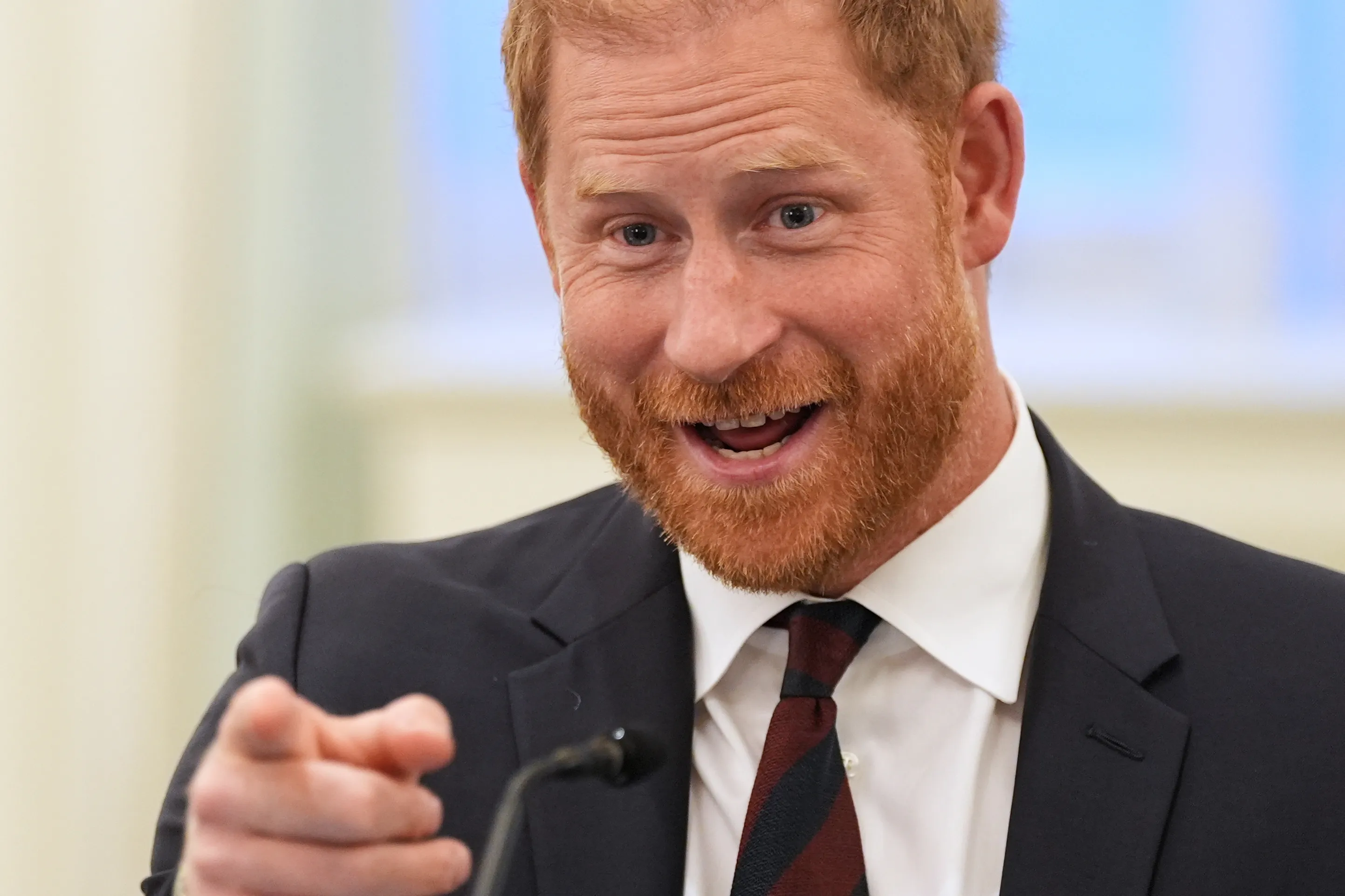 Prince Harry, Duke of Sussex, speaks at a roundtable about support for veterans, pointing towards the camera.