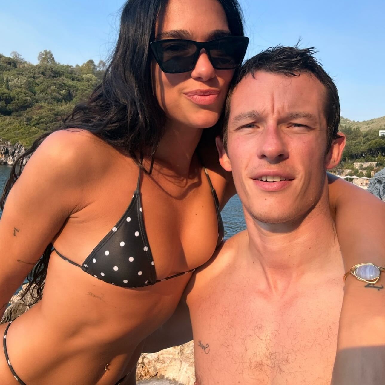 Dua Lipa and Callum Turner pose for a selfie in swimwear.