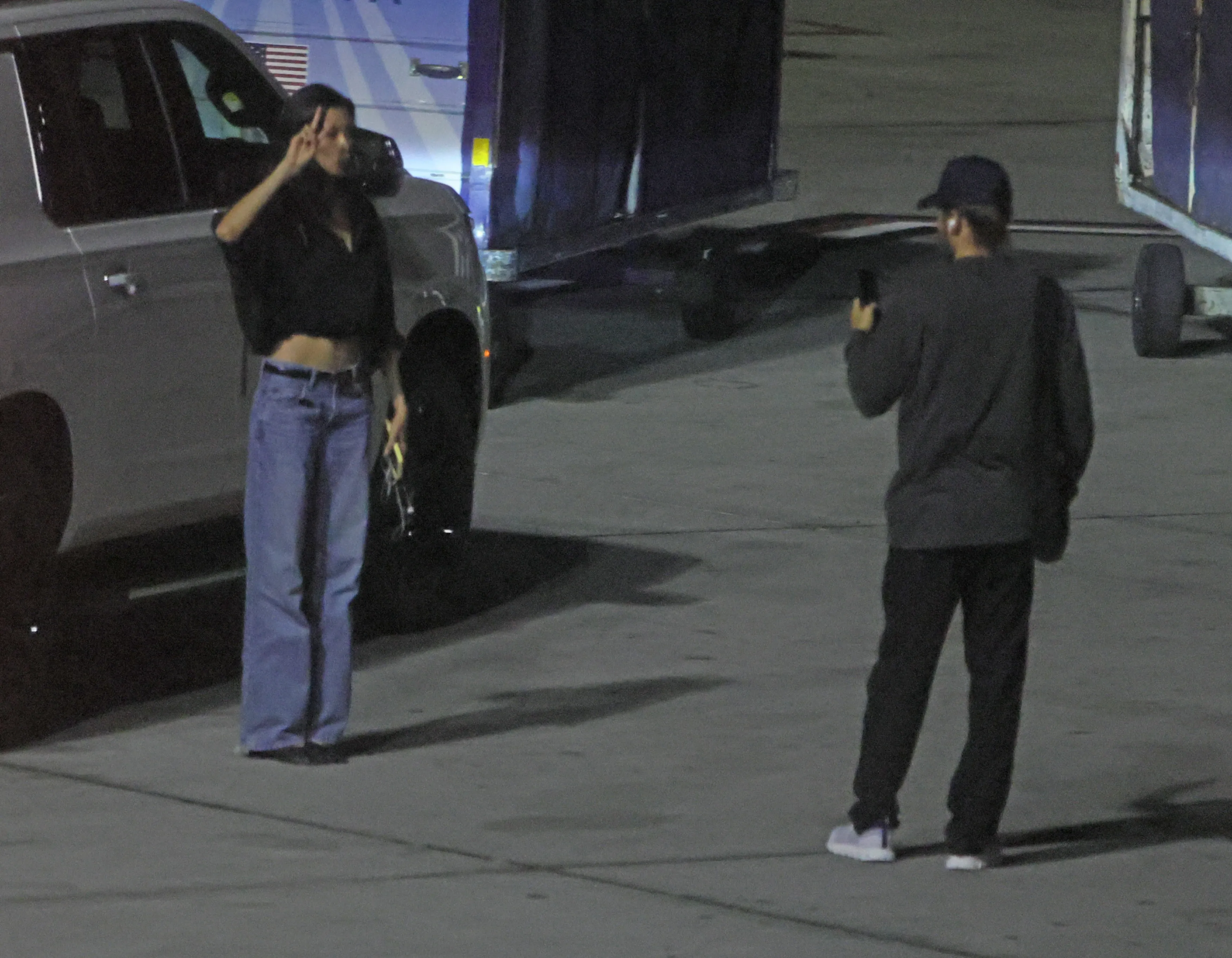 Model Thet Thinn making a peace sign gesture while Jared Leto records her at LAX.