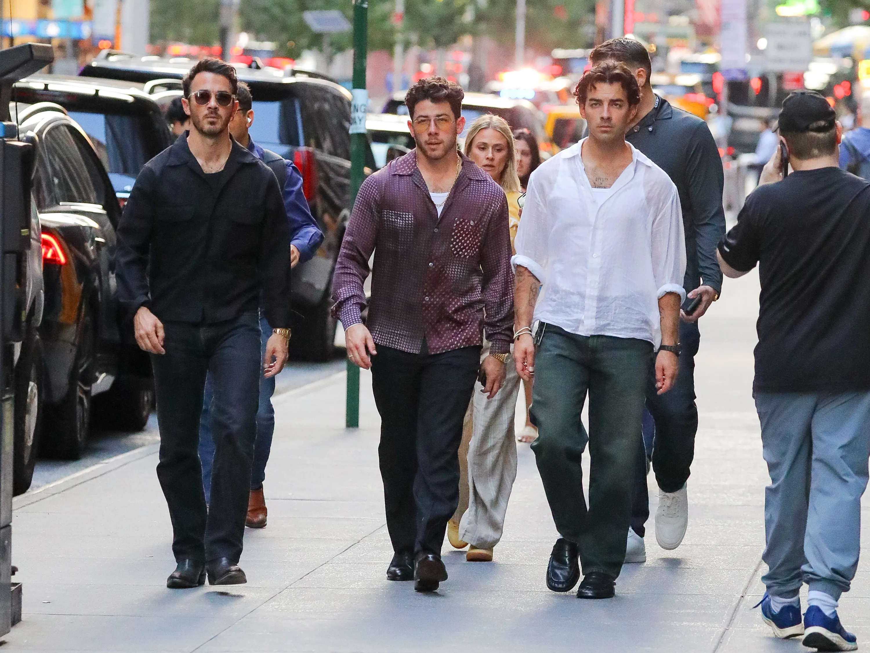 The Jonas Brothers walking through New York City.