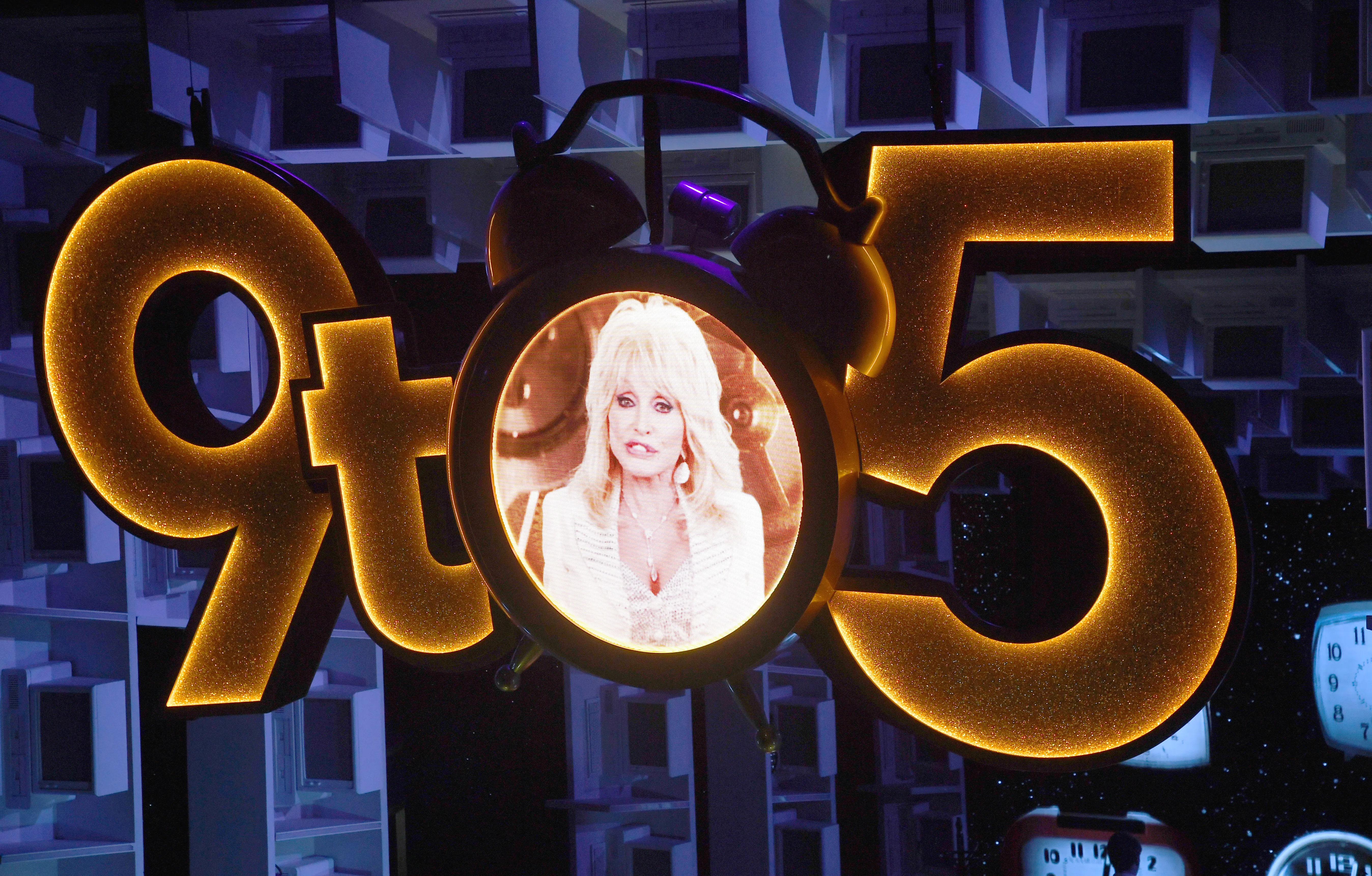 The "9 to 5" musical logo with a clock face showing Dolly Parton
