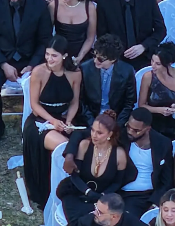 Kylie Jenner and Timothée Chalamet sitting together with other guests at a wedding.