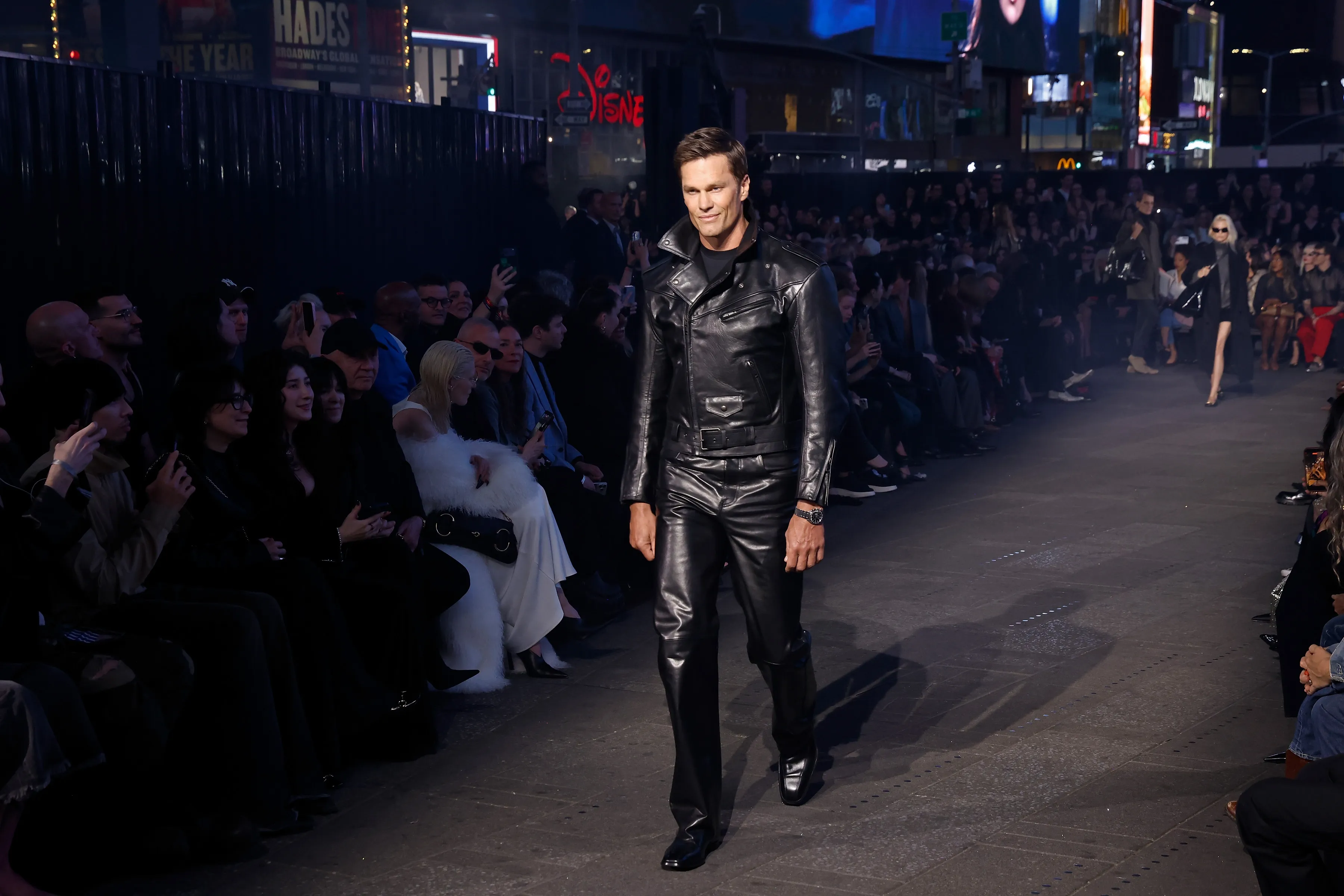 Tom Brady models a black leather outfit on the runway during the Gucci Cruise 2027 fashion show.