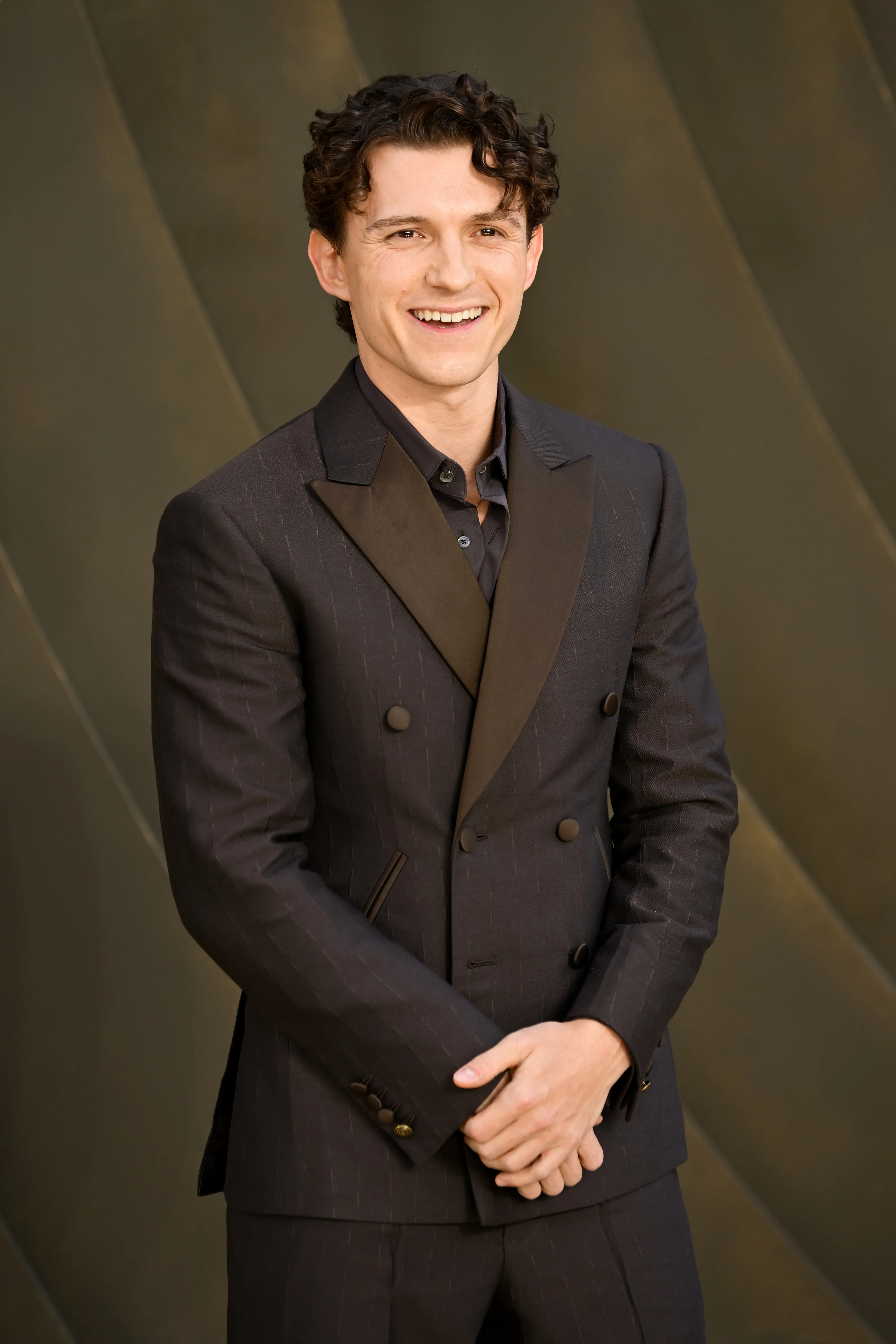 Tom Holland smiling at the world premiere of "The Odyssey."