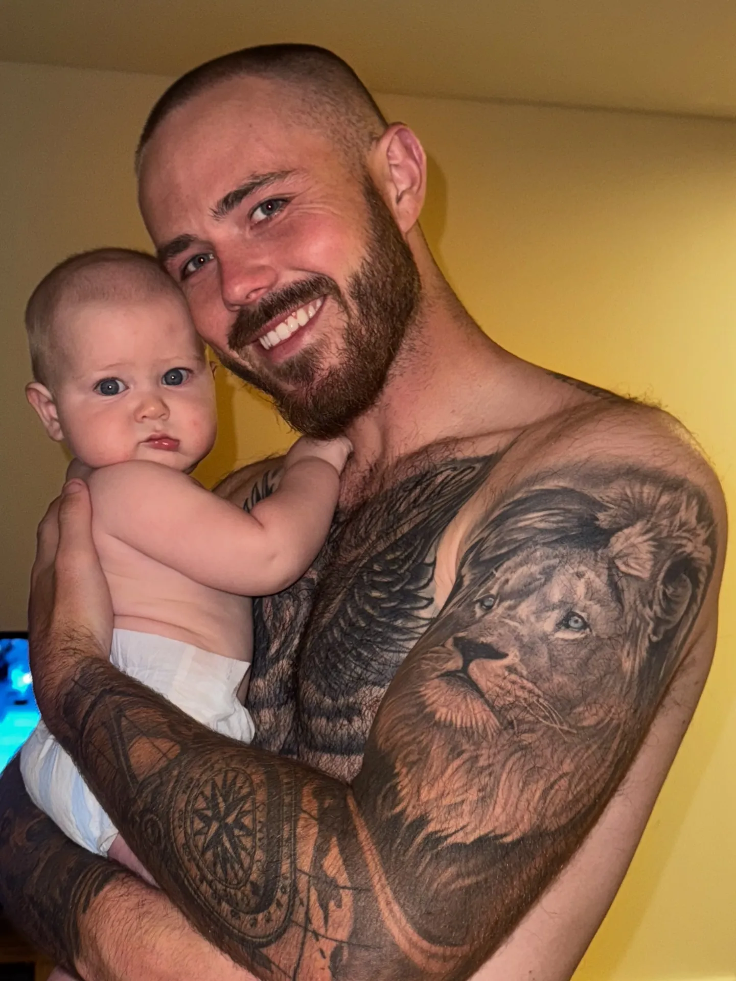 Nathan Gallagher holding a baby, both smiling.