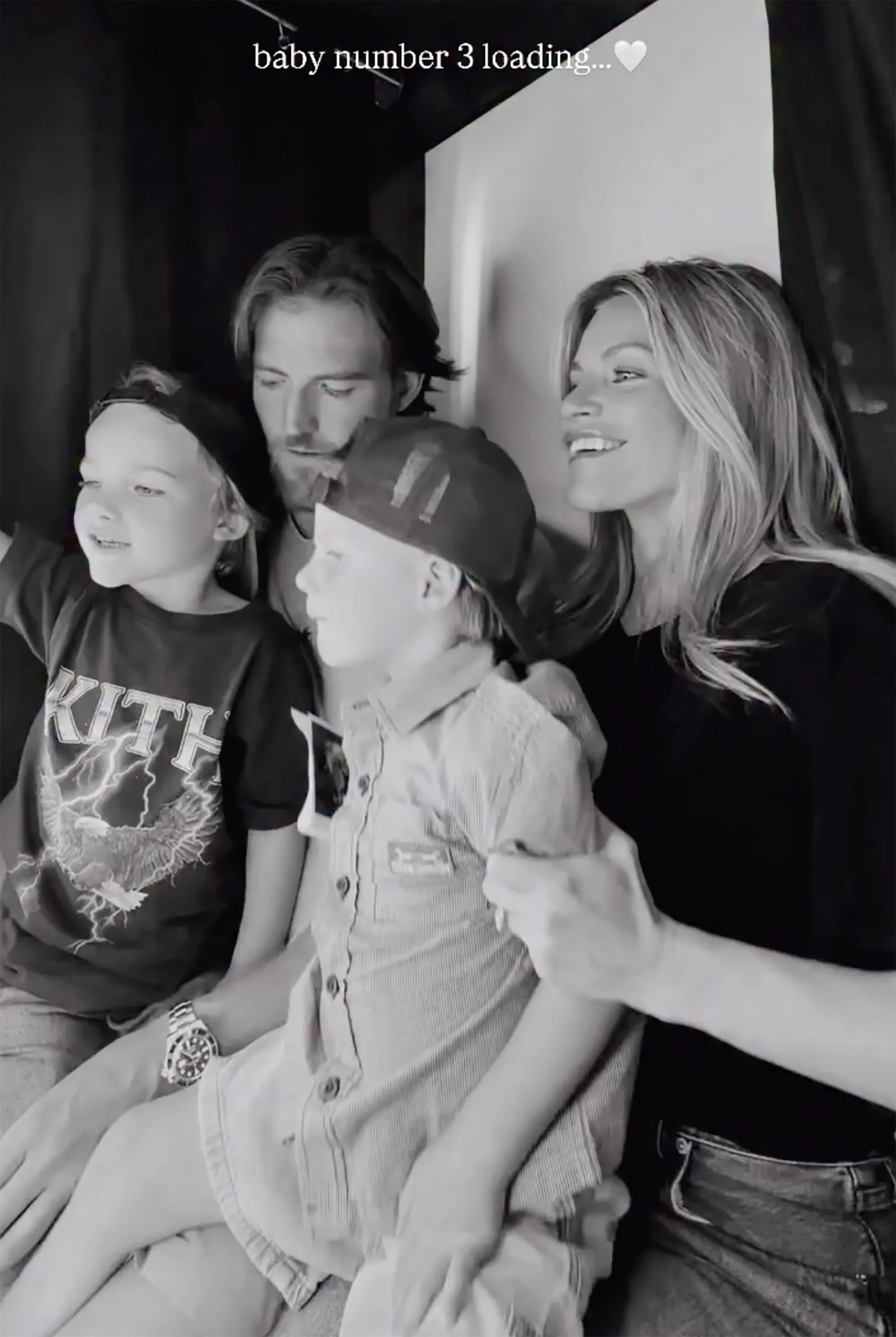 Black and white photo of Witney Carson, her husband, and their two children, with text "baby number 3 loading." indicating her pregnancy announcement.