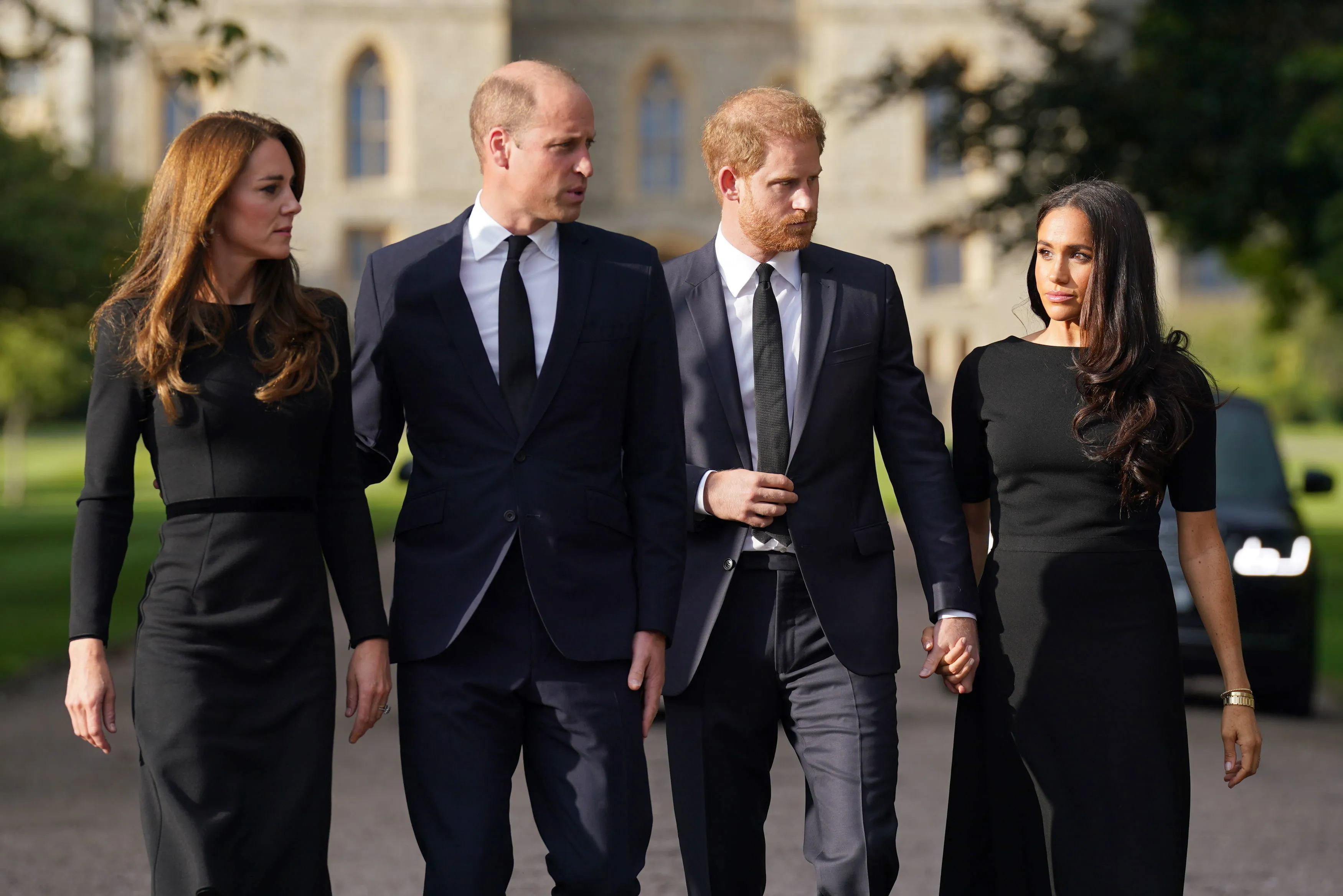 Catherine, Princess of Wales, Prince William, Prince of Wales, Prince Harry, Duke of Sussex, and Meghan, Duchess of Sussex, walk together in black formal attire.