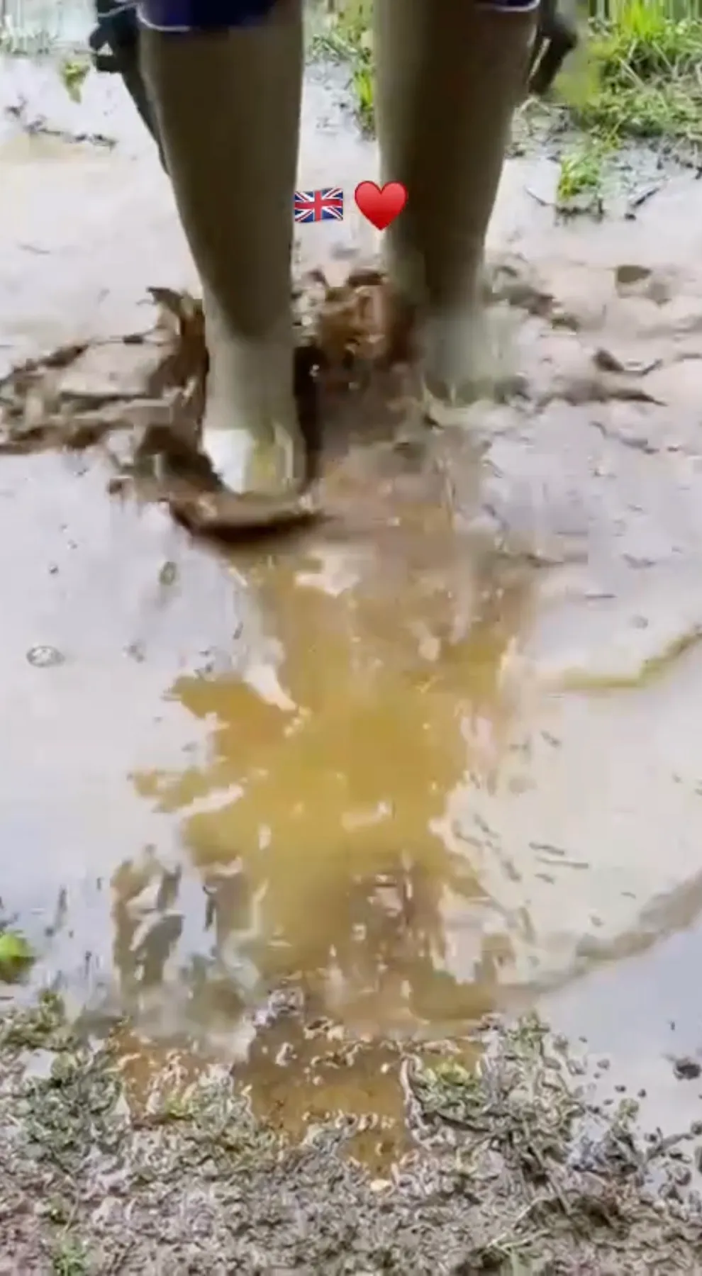 A person in green wellington boots stomping in a muddy puddle, with British flag and heart emojis.
