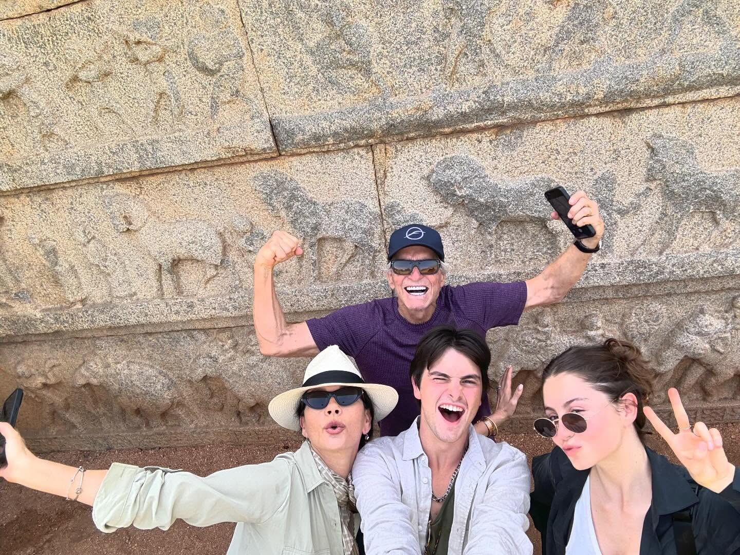 Catherine Zeta-Jones and Michael Douglas pose for a selfie with their children Carys and Dylan in front of an ancient stone wall.