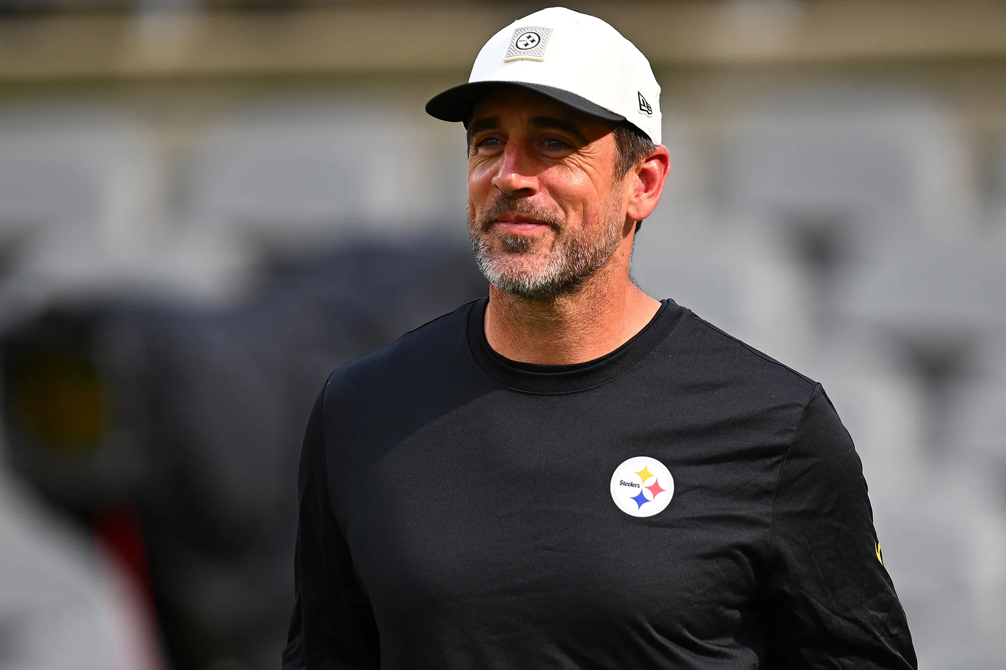 Aaron Rodgers smiling on the sidelines during a game