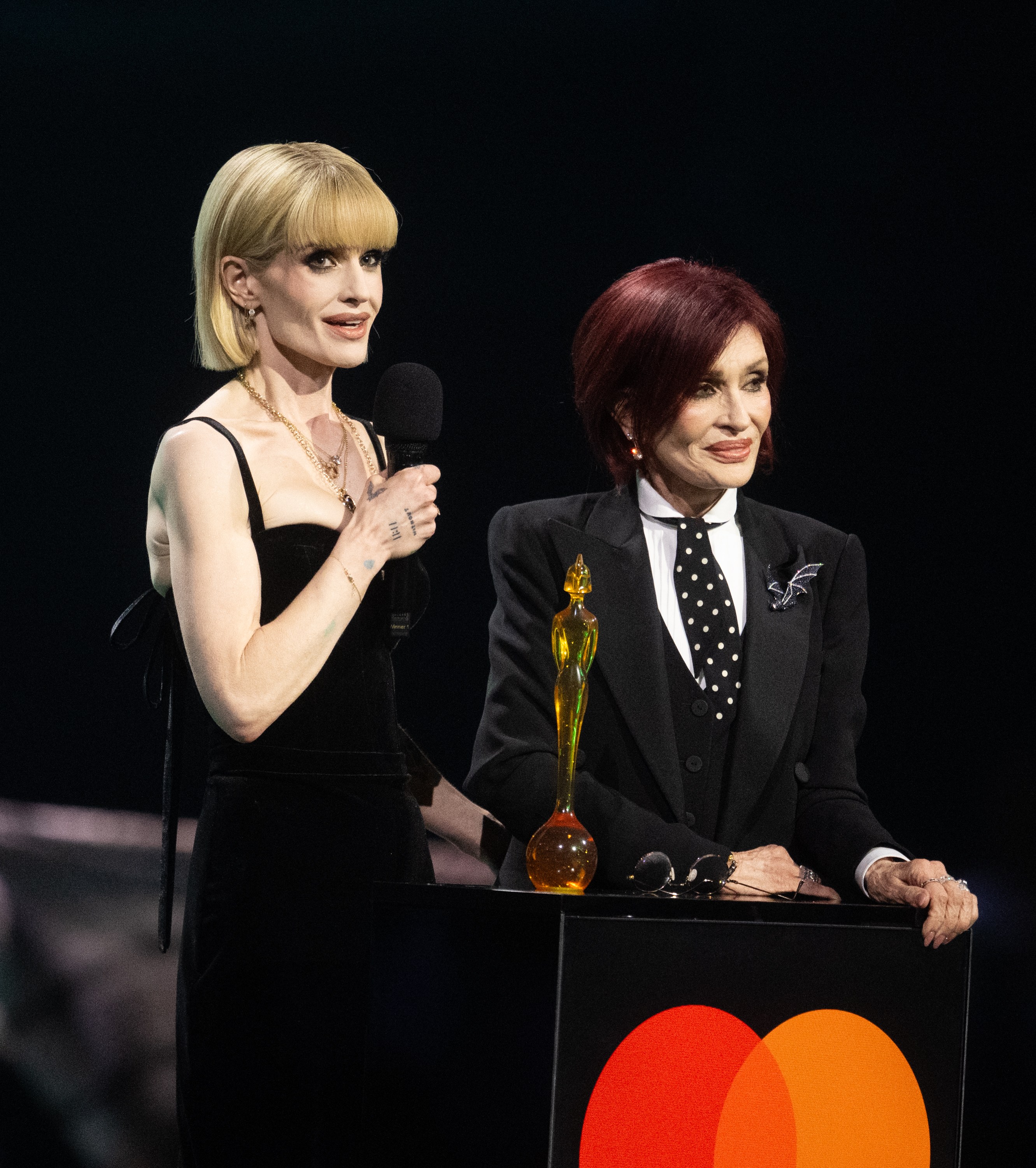 Kelly Osbourne and Sharon Osbourne on stage accepting the
