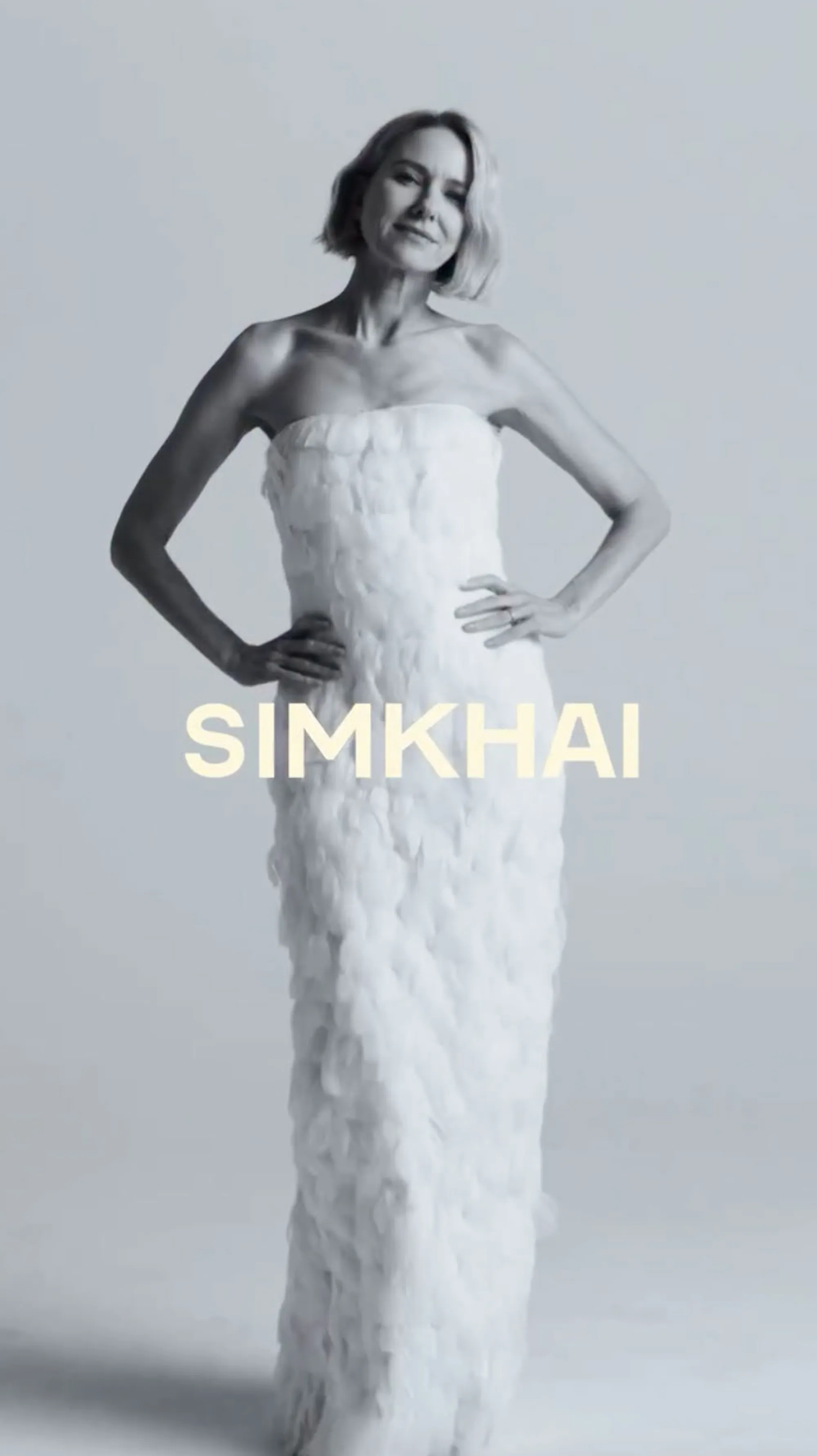 Naomi Watts in a white feathered strapless gown for SIMKHAI.