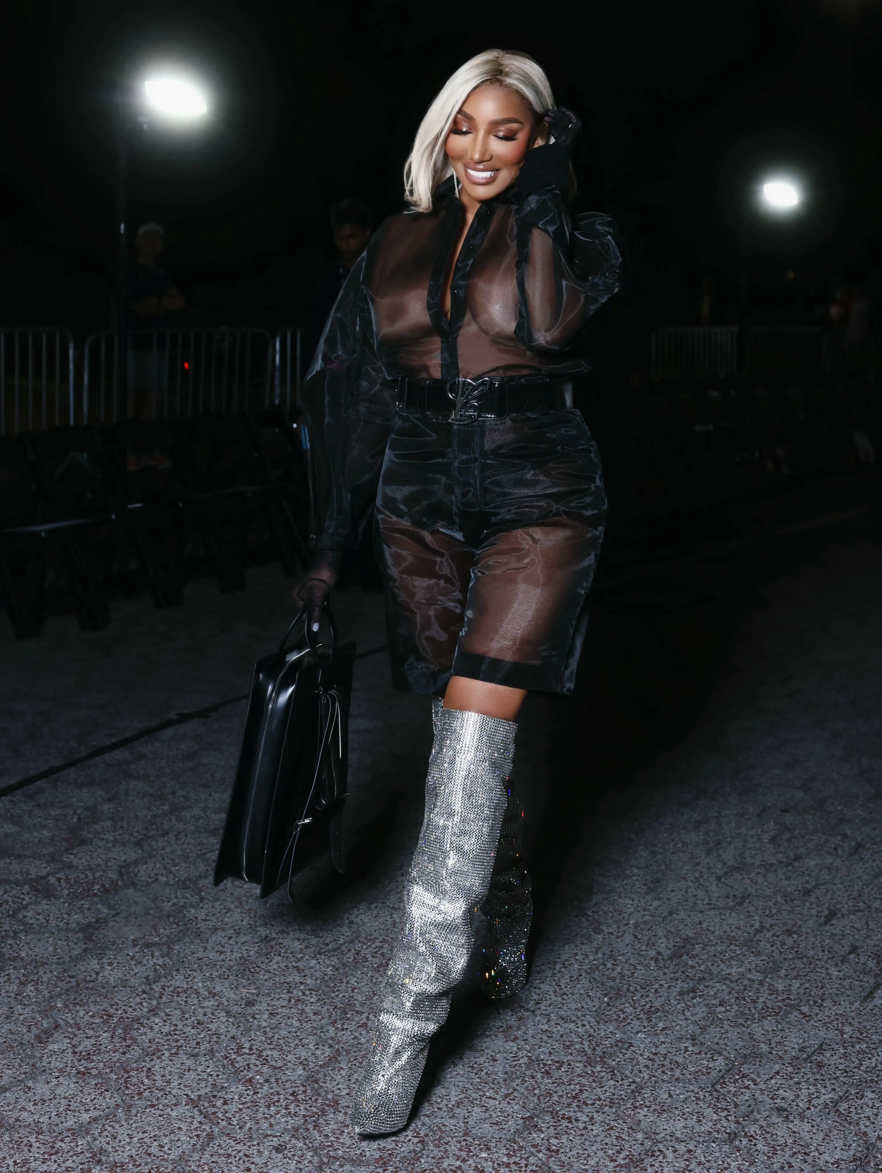 Nene Leakes at the Luar Show during NYFW, wearing a sheer black outfit and sparkling silver boots.