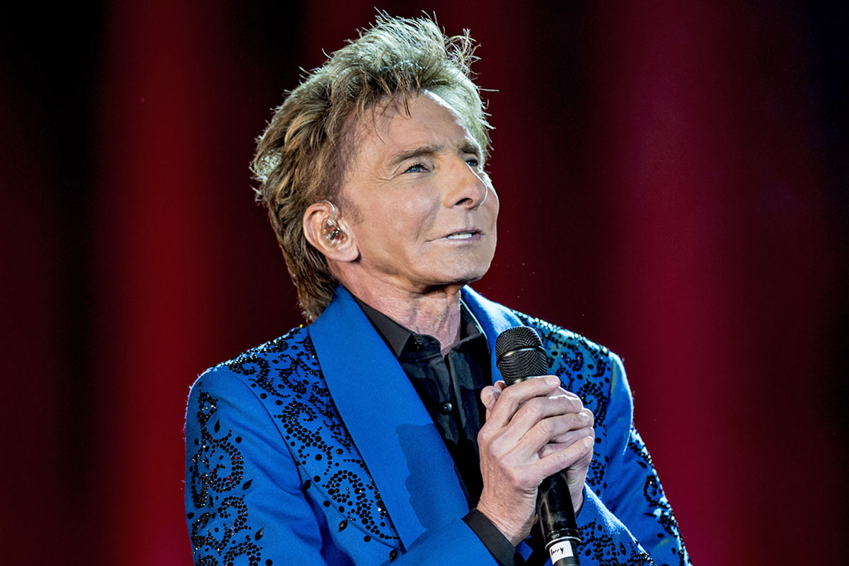Barry Manilow performing on stage during a concert showcase.